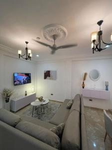 a living room with a couch and a ceiling fan at 2 Chambres Élégantes Confort Moderne in Santeo