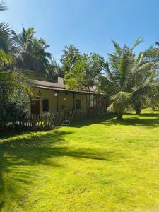 a house with palm trees in front of a yard at Tranquil Farmstay by Vanaja Farms in Rāmanagaram