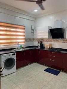 a kitchen with a stove and a washing machine at 2 Chambres Élégantes Confort Moderne in Santeo