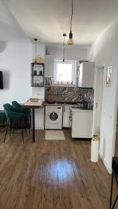 a kitchen with white appliances and a table and chairs at Bachner Rental Fagaras in Făgăraş