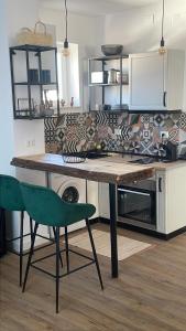 a kitchen with a wooden table and a green chair at Bachner Rental Fagaras in Făgăraş