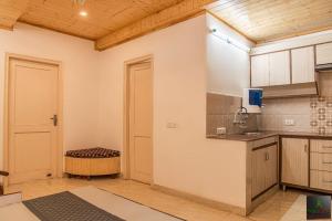 Zimmer mit einer Küche mit einer Theke und einer Tür in der Unterkunft Exotic Stays Kasauli I The Himalayan Edge I Serviced Apartments I Pvt Balcony I Peaceful Area I Family Accomodation I Kasauli in Kasauli