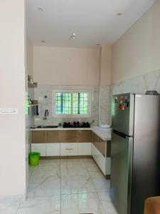 a kitchen with a refrigerator and a sink at Tranquil Farmstay by Vanaja Farms in Rāmanagaram