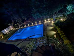 a large swimming pool with a blue screen at night at Lavish Resort Sigiriya in Inamaluwa