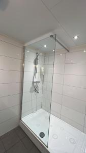 a shower with a glass door in a bathroom at Hotel Verhoeven in Uden