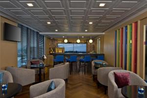 a restaurant with tables and chairs and a bar at Park Inn By Radisson Amritsar Airport in Amritsar