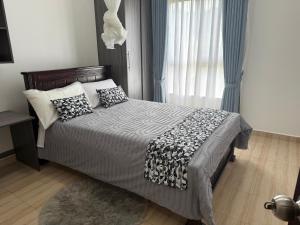 Un dormitorio con una cama con almohadas y una ventana. en Cozy 1-Bedroom Apartment at Pearl Marina, Garuga, en Entebbe