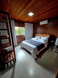 a bedroom with a bed and a wooden ceiling at Casa na Rampa - Hospedagem no Caravaggio in Santa Teresa