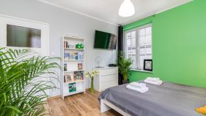 Habitación verde y blanca con cama y TV en Maya's - Duga 66, en Gdansk