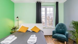 Un dormitorio con una cama y una silla azul. en Maya's - Duga 66, en Gdansk