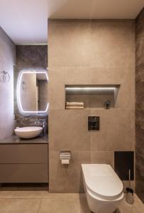 a bathroom with a toilet and a sink at Апартаменты с двумя спальнями с завораживающим видом на Днепр возле Мост Сити in Dnipro