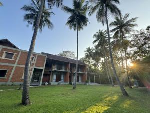eine Gruppe von Palmen vor einem Gebäude in der Unterkunft Arika Villa in Dambulla