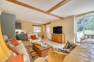a living room with a couch and a tv at Coach House in Tolpuddle