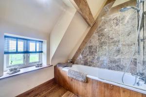 a bathroom with a tub and a window at Coach House in Tolpuddle +35 photos