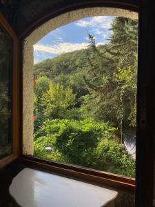 ein Fenster mit Waldblick in der Unterkunft Nuit entre mer et montagne in Caixas