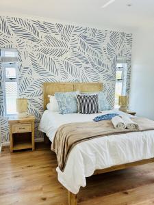 a bedroom with a bed with a black and white patterned wall at The White House - Kleinkrantz in Wilderness