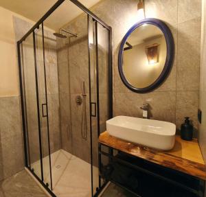 een badkamer met douche, wastafel en spiegel bij Rèfol Lodge Val di Ledro in Pur