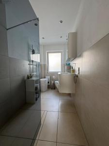 een grote badkamer met een wastafel en een spiegel bij Idyllische Wohnung mit Küche & Bad in Bielefeld in Bielefeld