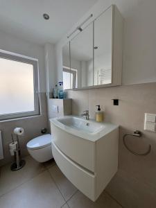 a bathroom with a sink and a toilet and a mirror at Idyllische Wohnung mit Küche & Bad in Bielefeld in Bielefeld