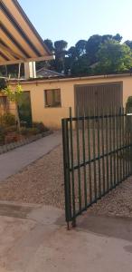 a green fence in front of a house at La casa nel borgo - le comodità di una intera casa vicina a tutti i servizi in Porto San Giorgio