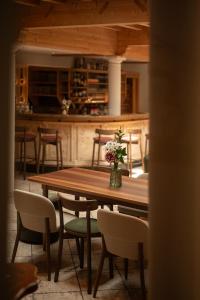 a wooden table and chairs with a vase of flowers on it at Vitalpina Hotel Schulerhof in Plaus