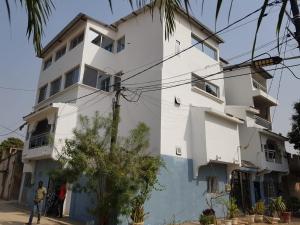 a white building with people standing in front of it at Résidence Keur Antou in Ziguinchor