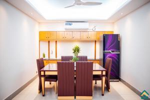a dining room with a table and a refrigerator at Tourister Bd Ltd in Dhaka