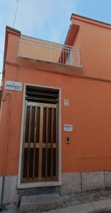 an orange building with a door and a balcony at Grotthouse in Andria