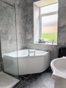 a white bath tub in a bathroom with a window at Whisky Row in Campbeltown
