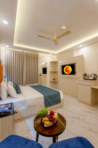 une chambre d'hôtel avec un lit et une table avec une assiette de fruits dans l'établissement Hotel Urban Lion - IGI Airport Delhi, à New Delhi