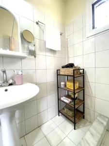 a bathroom with a sink and a shelf with towels at Captain's House in Kalymnos