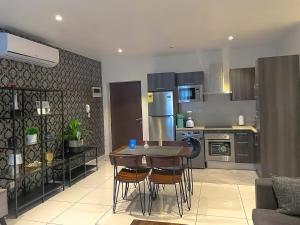 a kitchen with a table and chairs in a room at Embassy Onebedroom by Unique Abodes in Accra