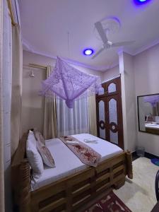 a bedroom with a bed with a purple ceiling at Kasai in Dodoma