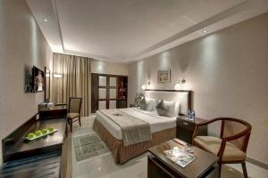 a large hotel room with a bed and a desk at Palm Beach Hotel in Dubai +24 photos