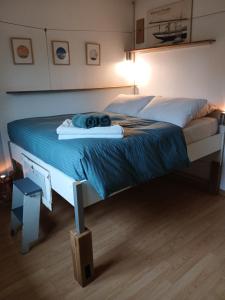 a large bed in a bedroom with a blue comforter at An Koad - Cabane au bord de l'eau in Plougastel-Daoulas