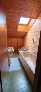 une salle de bain avec une grande baignoire et deux lavabos dans l'établissement Appartamenti Donatella, à Cavalese