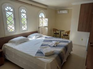 a bedroom with a bed with two towels on it at Pousada Dom Quixote in São João da Barra +107 photos