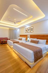 une chambre d'hôtel avec trois lits et un canapé dans l'établissement Hotel Urban Lion - IGI Airport Delhi, à New Delhi