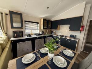 a kitchen with a wooden table with plates on it at King Carp in Tattershall