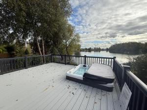 a bed sitting on top of a deck next to a river at King Carp in Tattershall +3 photos