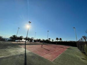 deux personnes jouant au tennis sur un court de tennis dans l'établissement Happy Camp Mobile Homes in El-Bahira Camping Village, à San Vito Lo Capo