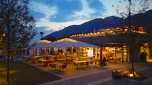 a restaurant with tables and chairs in a city at night at Campofelice Camping Village in Tenero