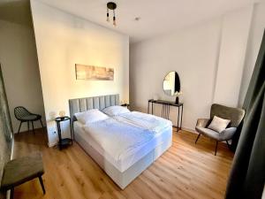 Un dormitorio con una cama, una silla y un espejo. en Luxury Holiday Apartment in Osnabrück 10304, en Osnabrück