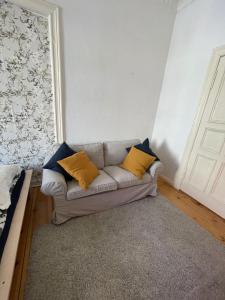 a living room with a couch with yellow pillows at Cozy room with private balcony, center berlin in Berlin