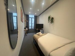 une petite chambre avec un lit et un miroir dans l'établissement Amsterdam Hotel, à Londres 16 autres photos