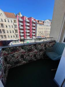 a balcony with a couch and a chair and buildings at Cozy room with private balcony, center berlin in Berlin