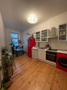 a kitchen with a red refrigerator and a wooden floor at Cozy room with private balcony, center berlin in Berlin