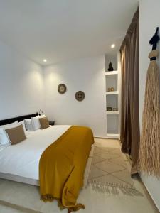 a bedroom with a bed with a yellow blanket on it at Riad 4 chambres, Piscine chauffée, Petit déjeuner inclus in Marrakesh +59 photos