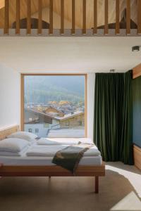 a bedroom with two beds and a large window at Haus Aerli in Ehrwald