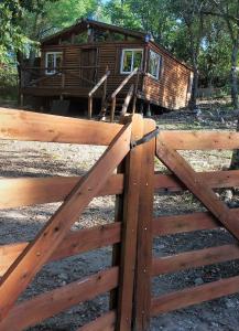 einem Holzzaun vor einer Blockhütte in der Unterkunft cabaña en el bosque in Valle Hermoso